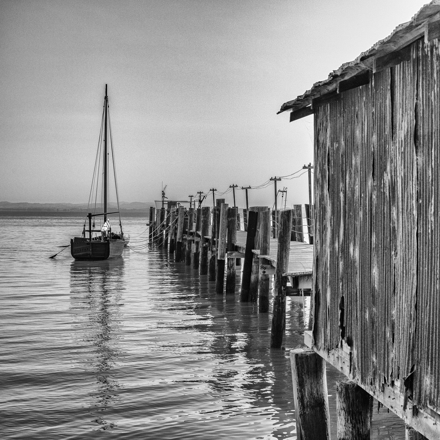 An old wooden boat tied to a pier