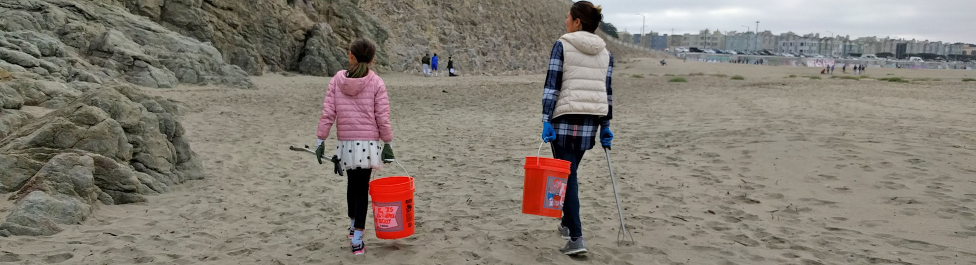 Mother and daughter with buckets and gloves at a cleanup