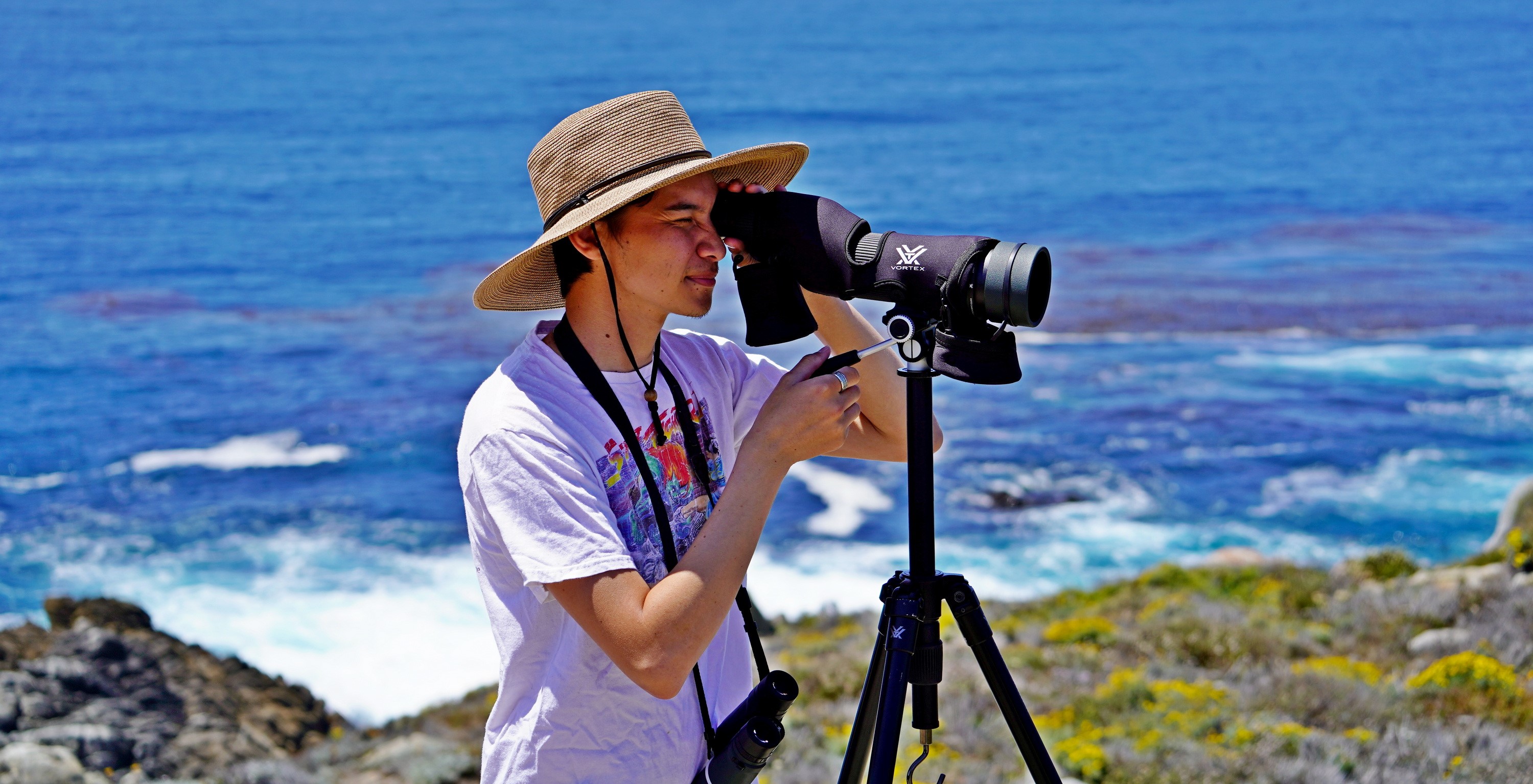 Miguel Alvarado using a spotting scope on the coast at Point Lobos